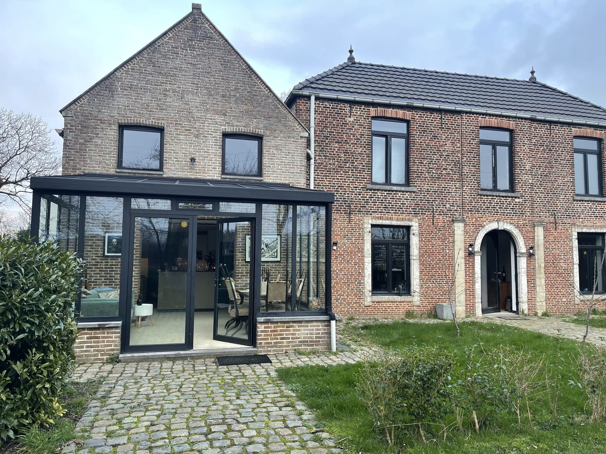 GreyHouse — historic Belgian estate with cobbled courtyard and glass conservatory